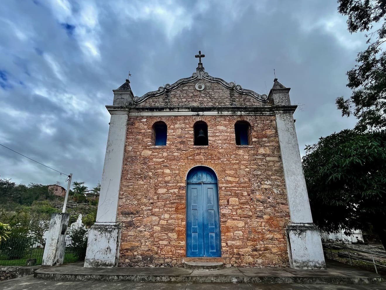 Igreja de pedra com porta azul em Igatu